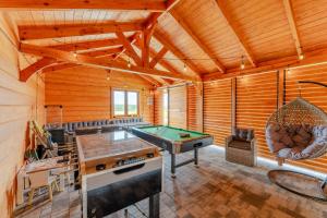 a room with a pool table in a log cabin at Siedlisko Malechowo in Ustronie Morskie
