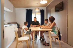 a group of people sitting at a table in a kitchen at ZEcamping 3 familial piscine club enfant animaux acceptés animations in Malgrat de Mar