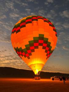 a large colorful hot air balloon in the desert at Desert Moments Camp in Al Wāşil