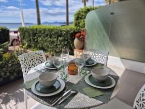 a table with plates and wine glasses on a patio at Juan Plage in Juan-les-Pins