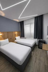 a hotel room with two beds and a tv at Kilic Boutique Hotel in Istanbul