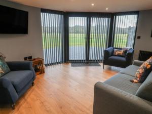 a living room with two couches and a flat screen tv at The Barley Silo in Ipswich