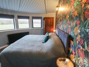 a bedroom with a bed in a room with windows at The Barley Silo in Ipswich
