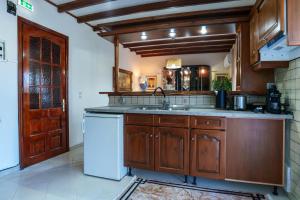 a kitchen with wooden cabinets and a white dishwasher at Zoe House in Sidari +18 photos