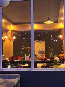 a window view of a restaurant with christmas lights at Casa Sonya in Aninoasa