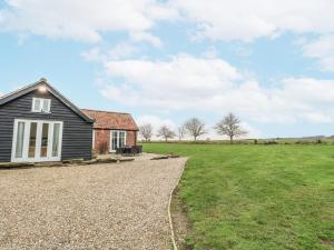 a house with a grassy field next to a building at Ivy Barn in Norwich