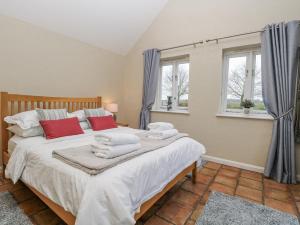 a bedroom with a large bed with towels on it at Ivy Barn in Norwich