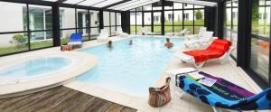 a large swimming pool with a hot tub and people in it at ZEcamping 3 étoiles pet friendly piscine chauffée et piscine couverte in Audierne