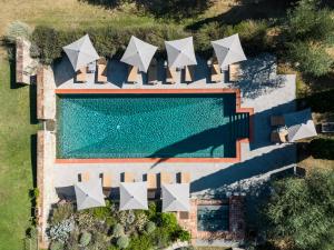 an overhead view of a swimming pool with white umbrellas at Fontelunga Hotel & Villas in Pozzo