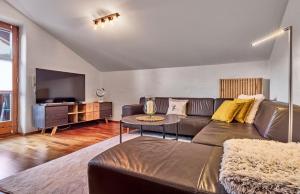 a living room with a leather couch and a tv at Ferienwohnung Fritz in Bodenmais