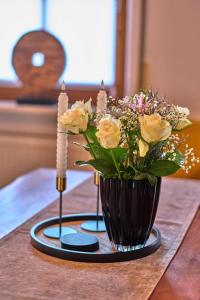 a vase with yellow roses on a table at Ferienwohnung Fritz in Bodenmais