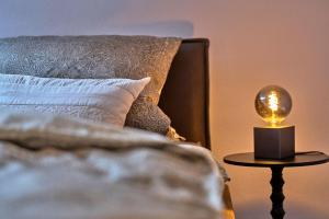 a bed with a lamp on a table next to it at Ferienwohnung Fritz in Bodenmais +18 photos
