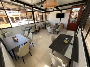 a restaurant with tables and chairs in a room at Hotel Wilson Anexo in Liberia