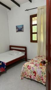 a bedroom with two beds and a window at Ecopolis hospedajes casa de campo tradicional in Papagalleros