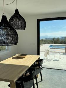 a dining room with a table and a view of a pool at Casa Horizonte in Iznájar +15 photos