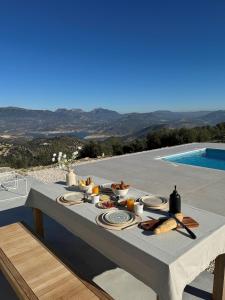 a table with food on it next to a pool at Casa Horizonte in Iznájar