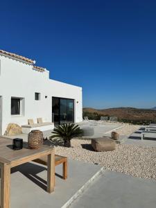 a white house with a bench and a table at Casa Horizonte in Iznájar