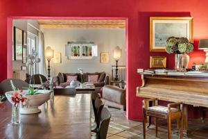a living room with red walls and a piano at Fontelunga Hotel & Villas in Pozzo