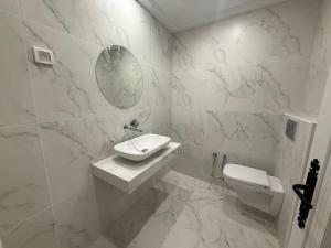a white bathroom with a sink and a toilet at Yocca Hotel Residence in Hammamet