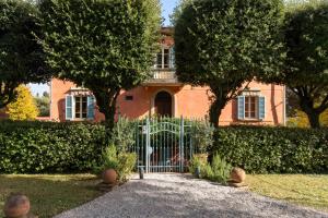 a gate in front of a house with trees at Fontelunga Hotel & Villas in Pozzo