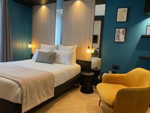 a hotel room with a bed and a chair at Grand Hôtel Clichy Paris - Boutique Hôtel in Clichy