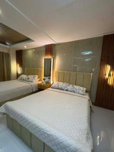 a bedroom with two beds and a flat screen tv at CEEJ Building Transient Studio Rooms in Iloilo City