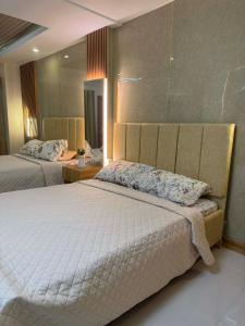 a bedroom with two beds and a mirror at CEEJ Building Transient Studio Rooms in Iloilo City +26 photos