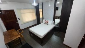a small room with a bed and a chair at Hotel Wilson Anexo in Liberia