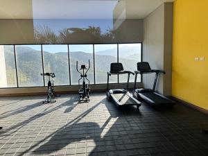 a gym with two exercise bikes and a large window at Rodadero Ocean View Luxury Apt with Rooftop Pool in Taganga