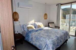 a bedroom with a blue and white bed and a window at Rodadero Ocean View Luxury Apt with Rooftop Pool in Taganga +31 photos