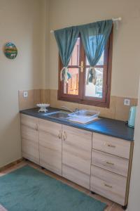 a kitchen counter with a sink and a window at Themelina Studios in Emborios +137 photos
