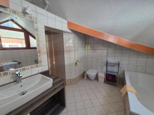 a bathroom with a sink and a tub and a toilet at Haus Gande in Spiss +8 photos