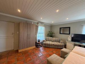 a living room with a couch and a television at Windkraal Farm Studio in Bonnievale