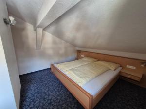 a small bedroom with a bed in a attic at Haus Gande in Spiss
