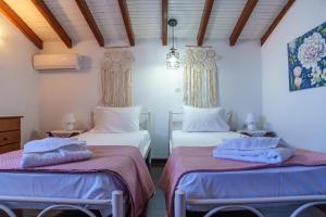 two beds in a room with two bedsitures at Zoe House in Sidari