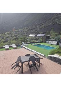a table and chairs on a patio with a pool at FINCA LA JORADITA in Tamaduste