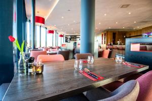 a wooden table in a restaurant with pink chairs at Bastion Hotel Amersfoort in Amersfoort +23 photos