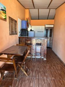 a room with a table and a kitchen with a counter at Sereia beach chalé in Icapuí