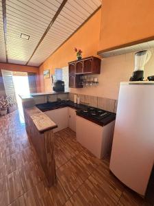 a kitchen with a refrigerator and a counter top at Sereia beach chalé in Icapuí