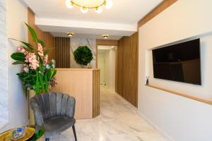 a living room with a chair and a television at Hotel Letos Mamaia Nord in Mamaia Sat/Năvodari