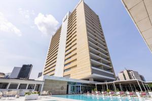 a tall building with a swimming pool in front of it at EPIC SANA Luanda Hotel in Luanda +32 photos