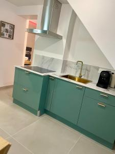a kitchen with blue cabinets and a sink at Romantic Suite & Jungle in Longjumeau +9 photos