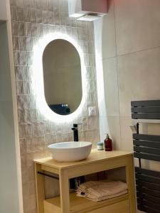 a bathroom with a sink and a mirror at Romantic Suite & Jungle in Longjumeau