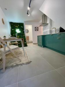 a kitchen with green cabinets and a table in it at Romantic Suite & Jungle in Longjumeau