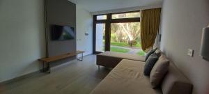 a living room with a couch and a large window at Fruit Village Torre dell'Orso La Brunese 4stelle in Torre dell'Orso