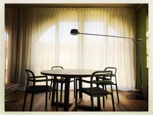 a table and chairs in a room with a lamp at La Trifola in Scurzolengo