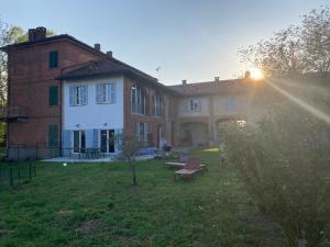 a large brick house with the sun setting behind it at La Trifola in Scurzolengo