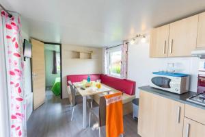 a small kitchen with a table in a caravan at ZEcamping 3 étoiles animaux acceptés avec piscine chauffée à Guérande in Guérande