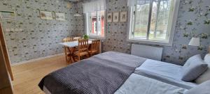 a bedroom with a bed and a table and chairs at Sävö Vandrarhem & Café in Västerljung
