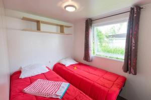 two red beds in a small room with a window at ZEcamping 3 étoiles animaux acceptés avec piscine chauffée à Guérande in Guérande +43 photos